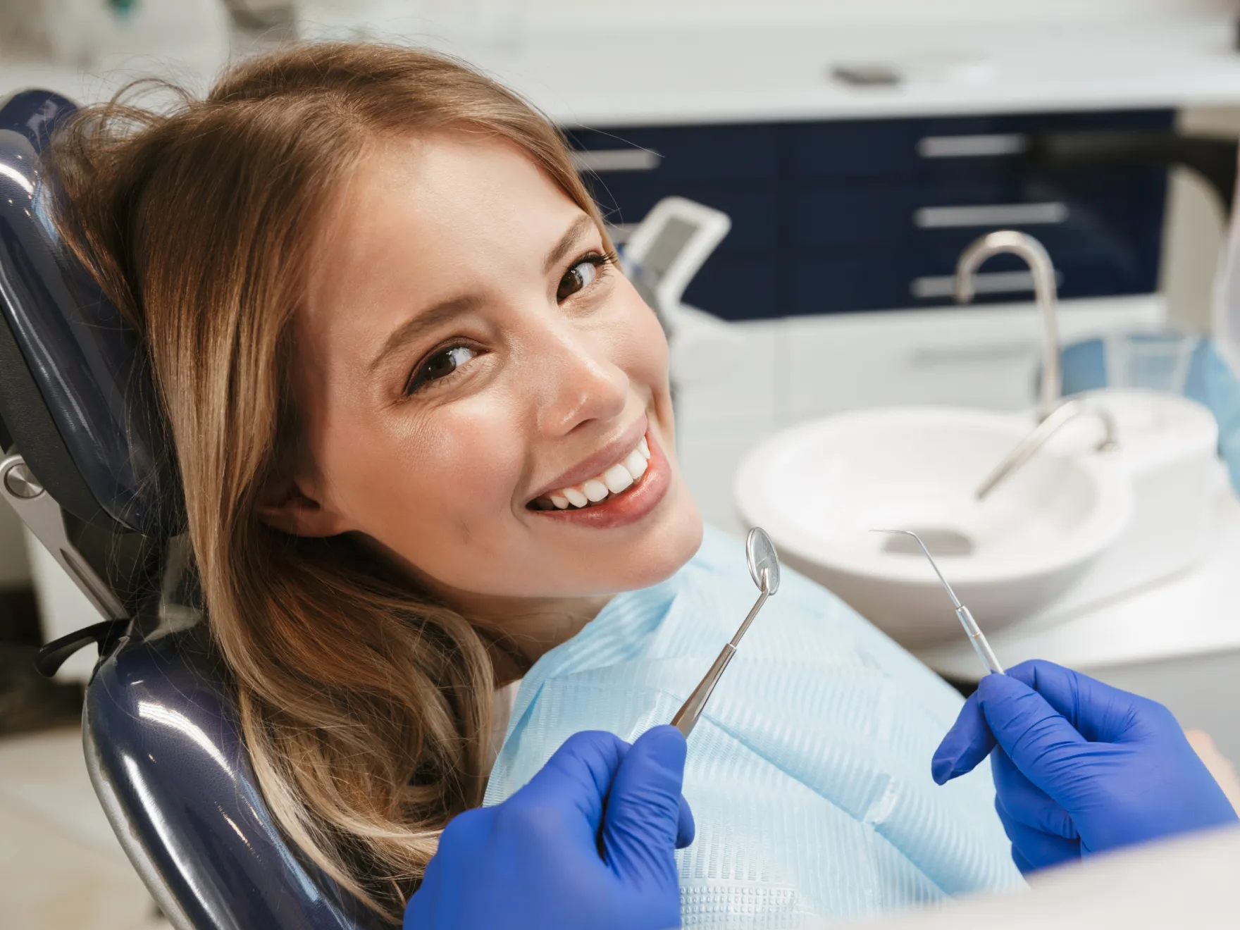 Patient smiling while getting her teeth  checked