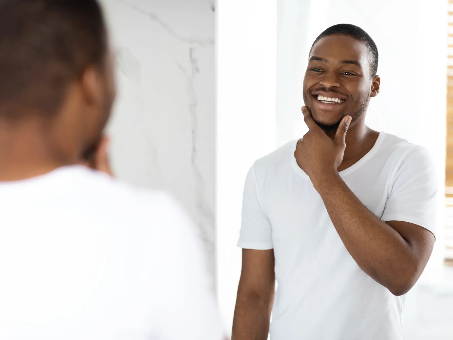 man checking smile in the mirror
