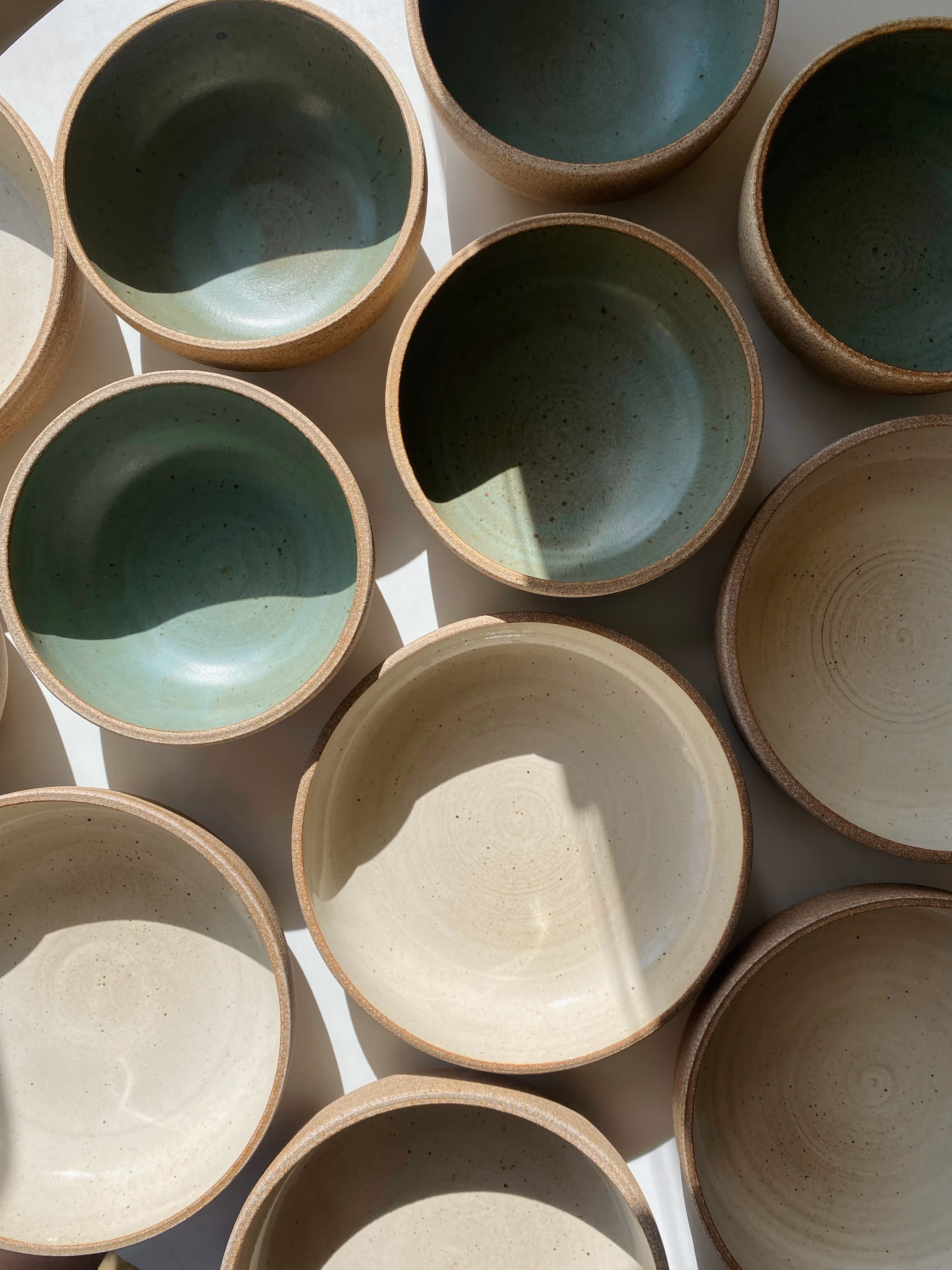 Blue cereal bowls, and off-white speckled large bowls.