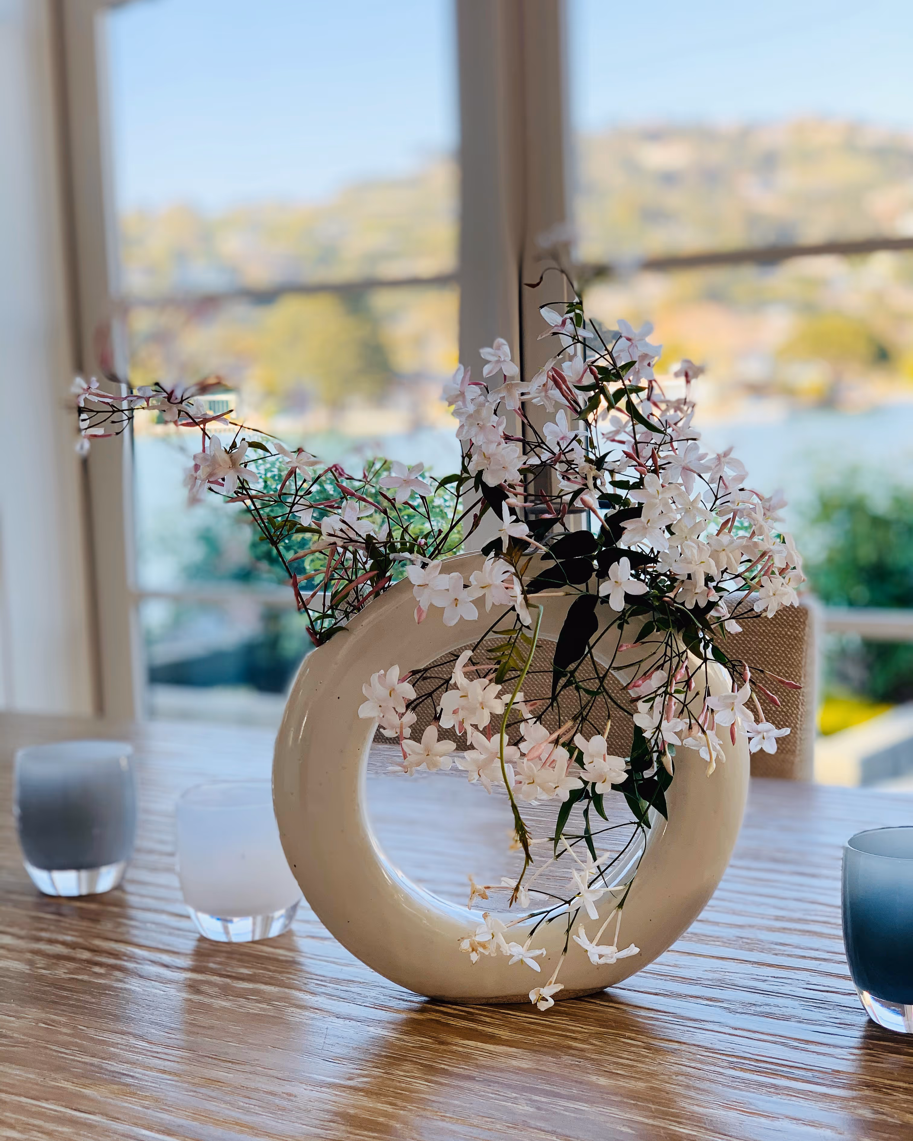 Loop vase adorned with flowers on a dining table.