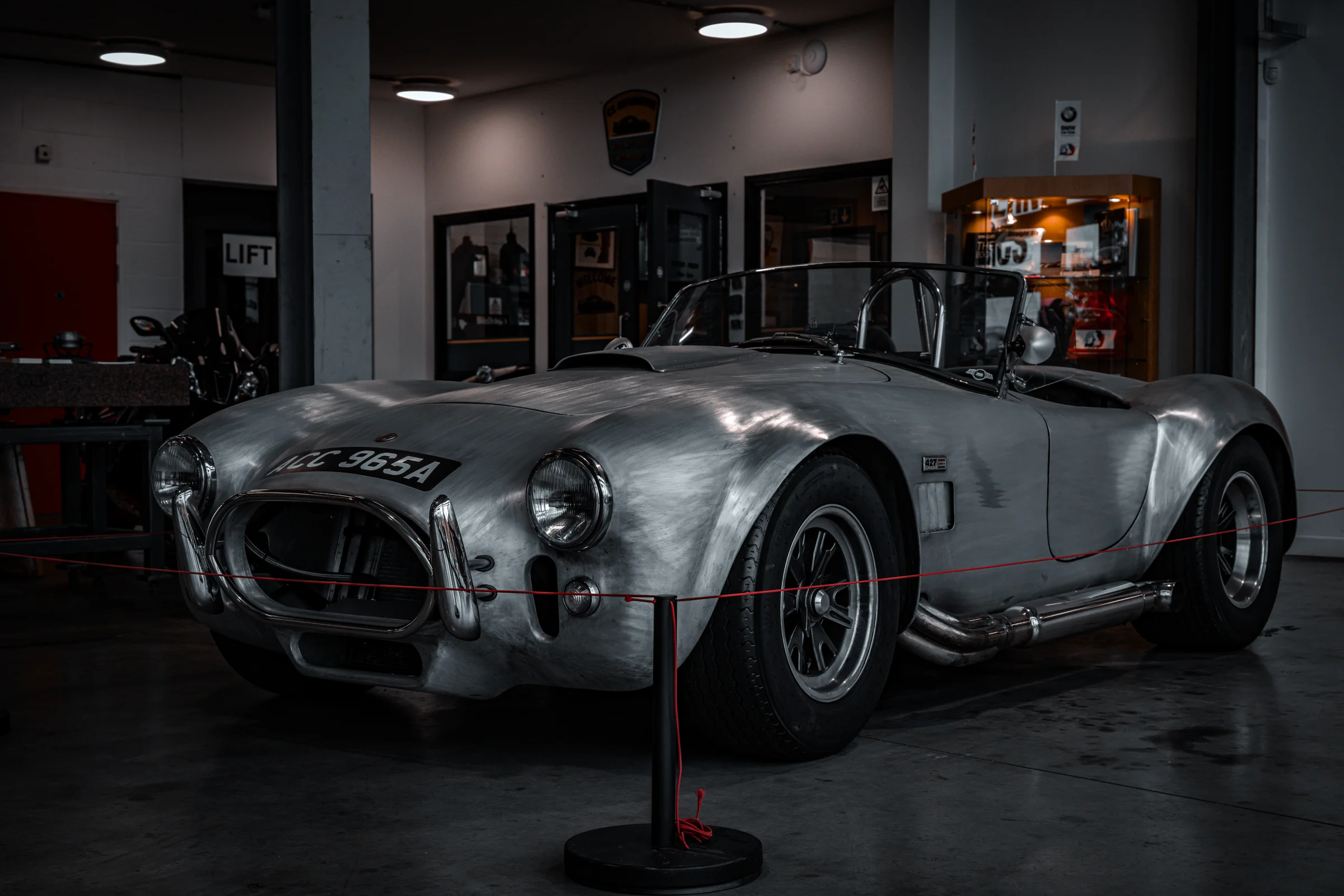 Brushed-metal AC Cobra displayed at Auto RARA