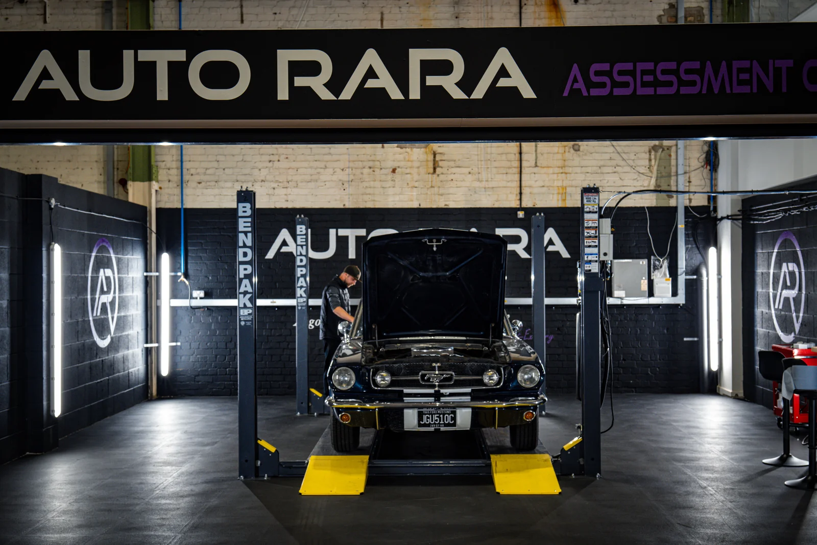 Ford Mustang with its bonnet open on a lift in Auto RARA’s assessment area.