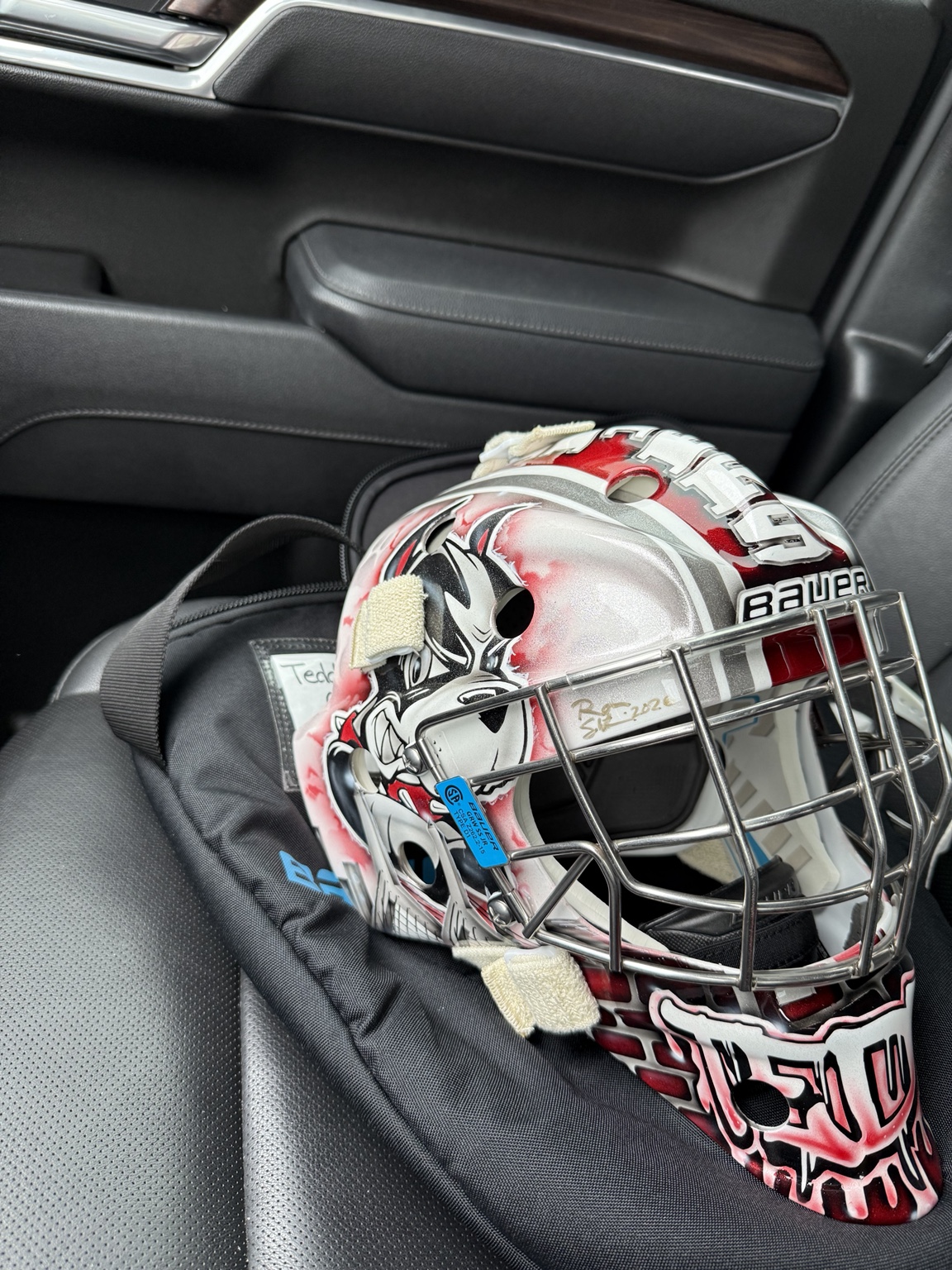Teddy's custom goalie helmet sitting on his gear bag in the car