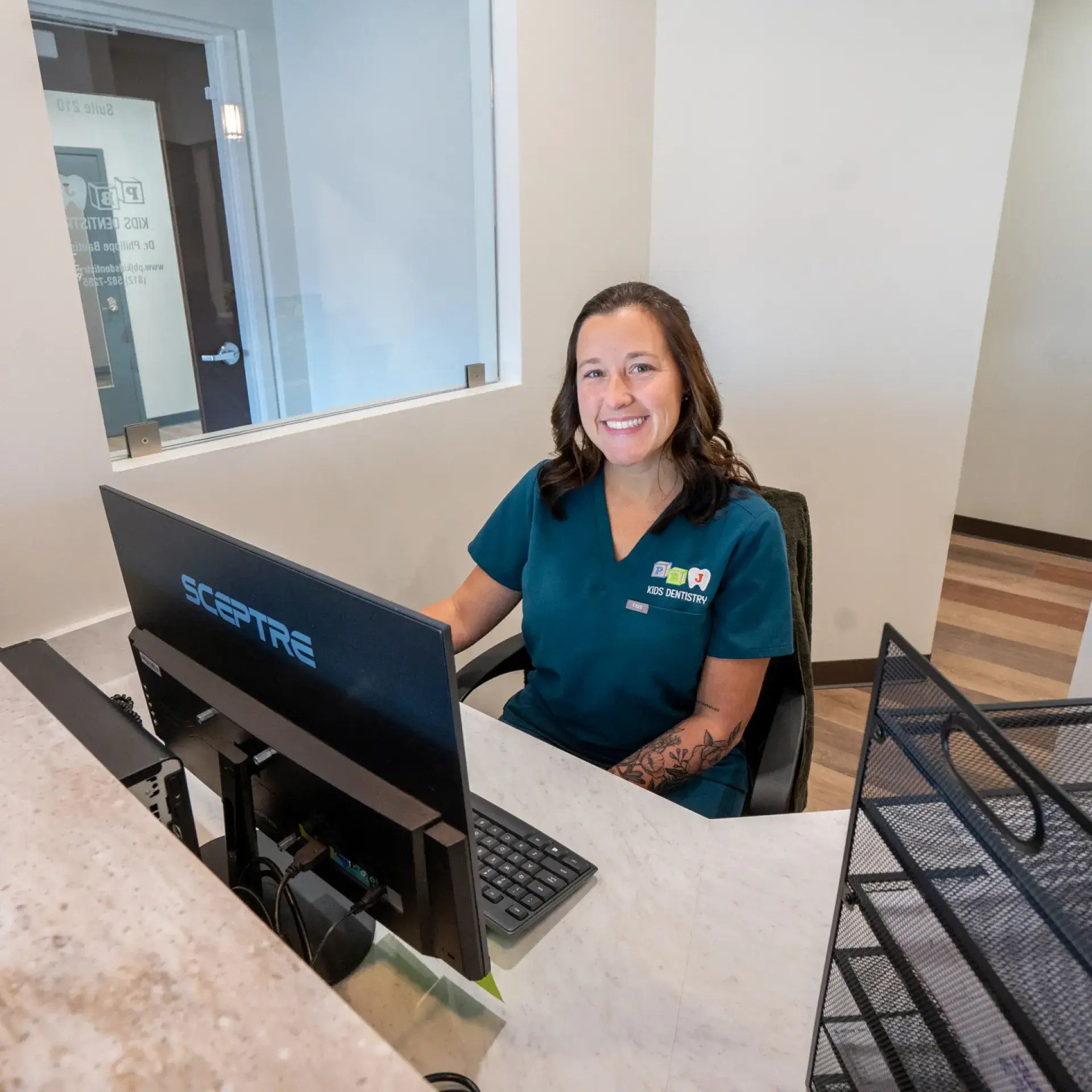 A woman sitting at a desk in front of a computer.