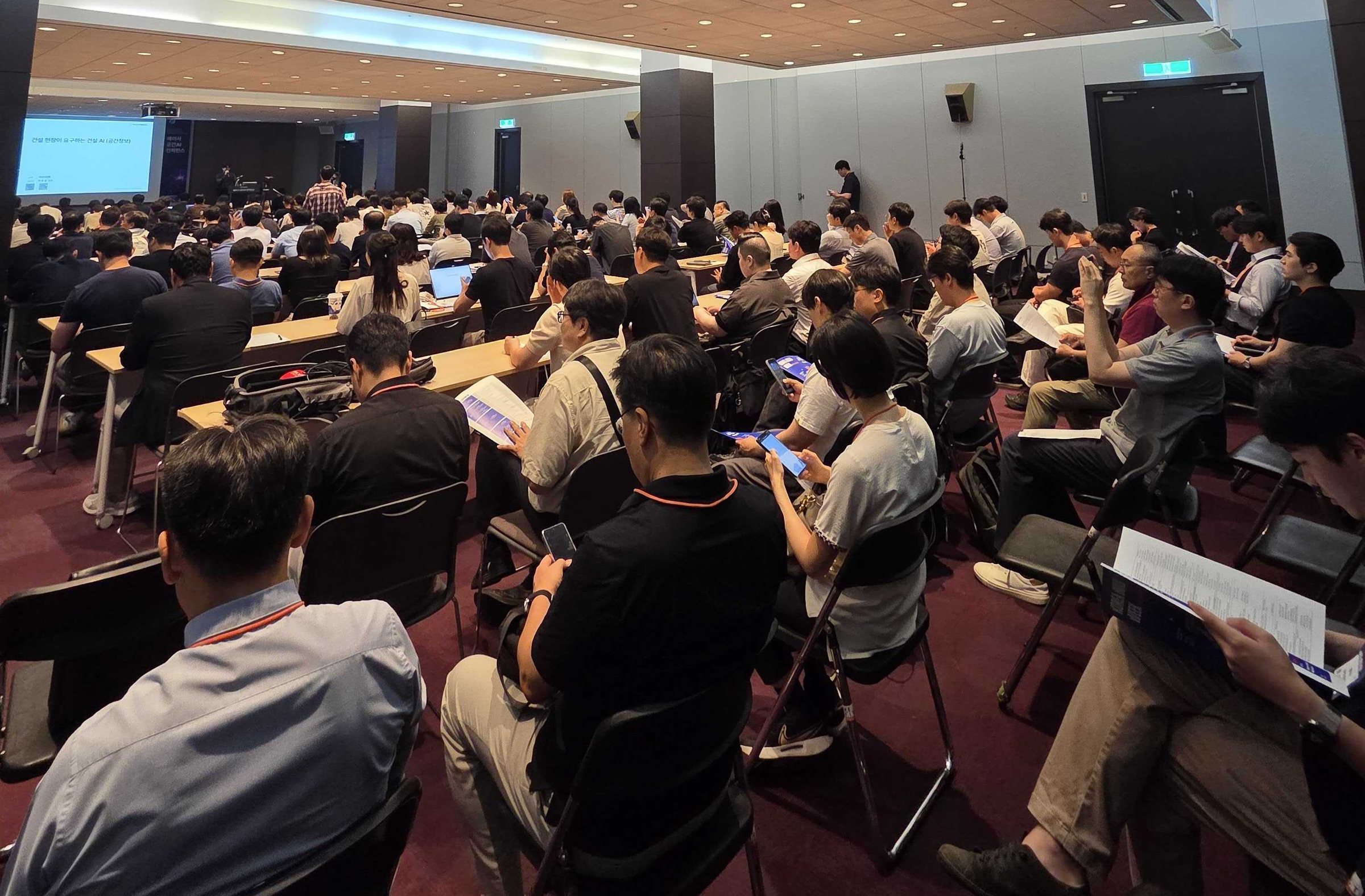 2026 메이사 공간AI 컨퍼런스 현장. 코엑스 세미나장을 가득 채운 건설사 실무자들과 발표 화면.
