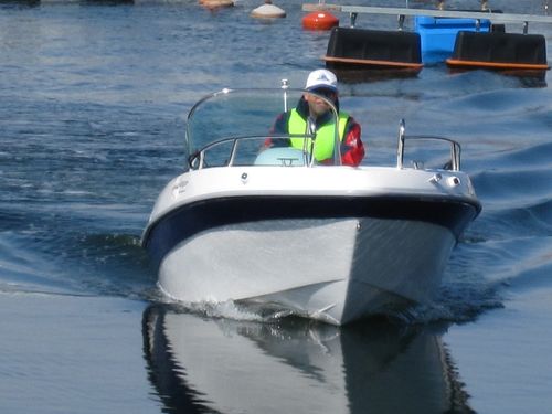 "EMILI 460" sports motor boat steered by male adult on the water