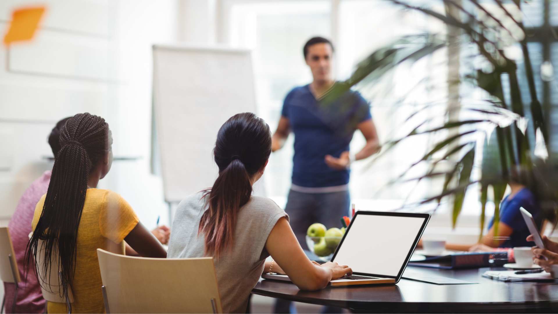 Salle de classe avec élèves devant et professeur en arrière plan