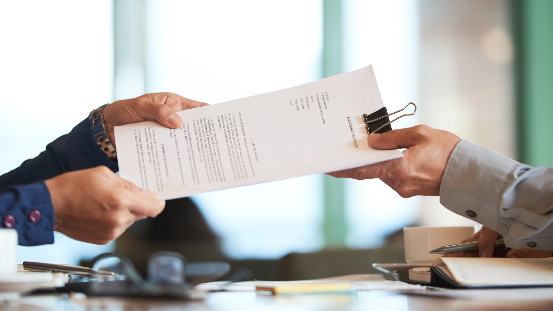 Les mains d'une personne donnent des document à une autre.