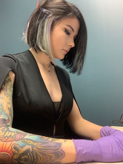 Picture of Madison giving a tattoo.