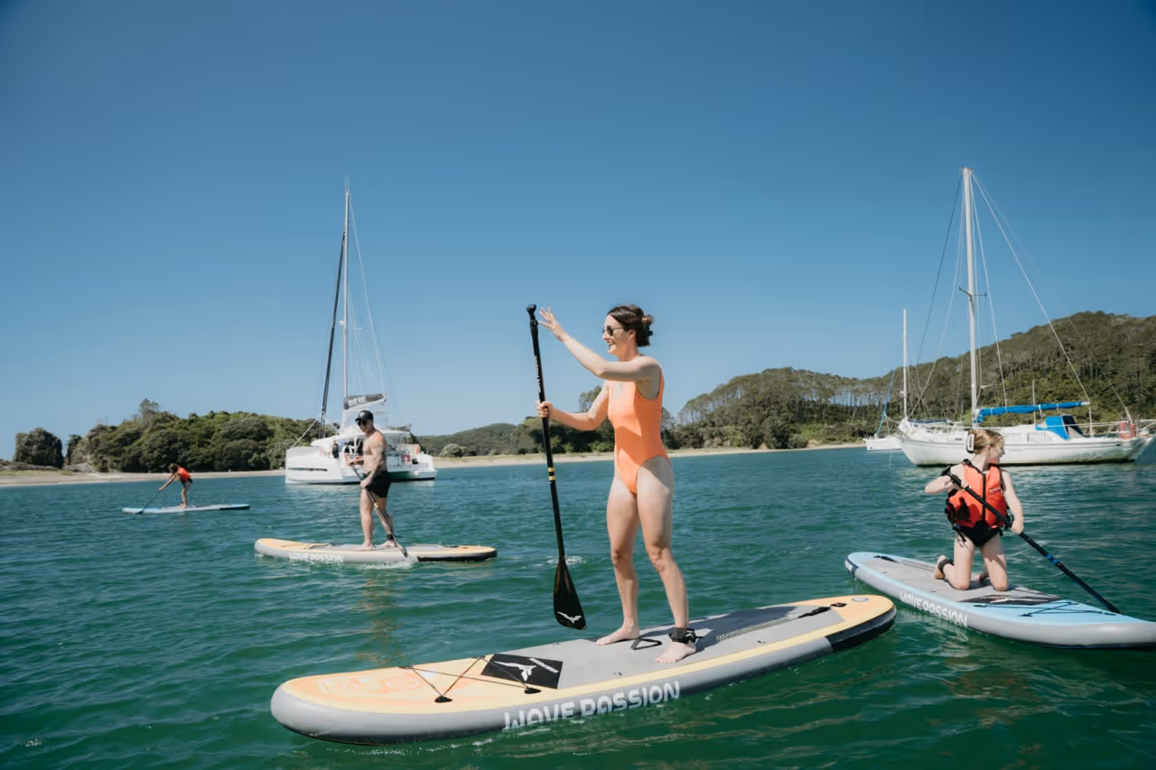 Family paddleboarding at Motuarohia Island, Bay of Islands, New Zealand