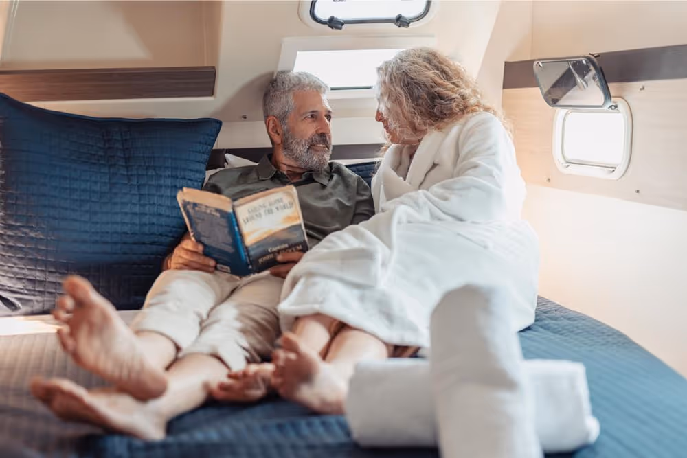Couple relax reading a book in stateroom of Serenity