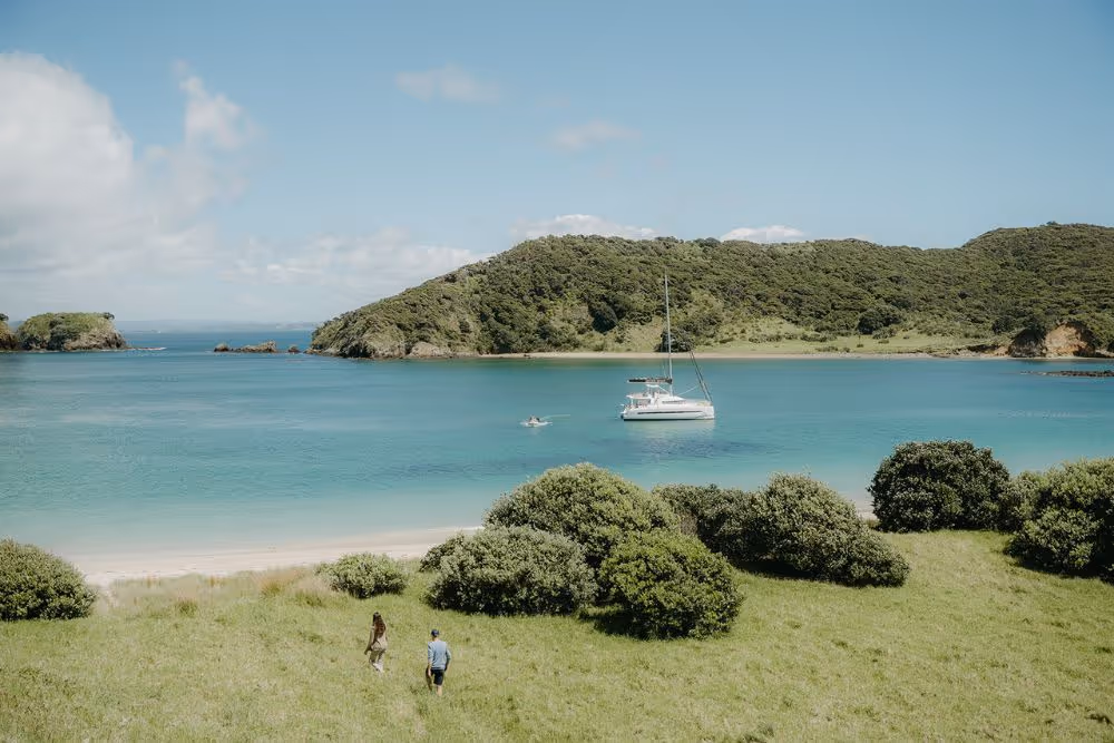 Couple return from walk Waewaetorea Island, Bay of Islands, New Zealand