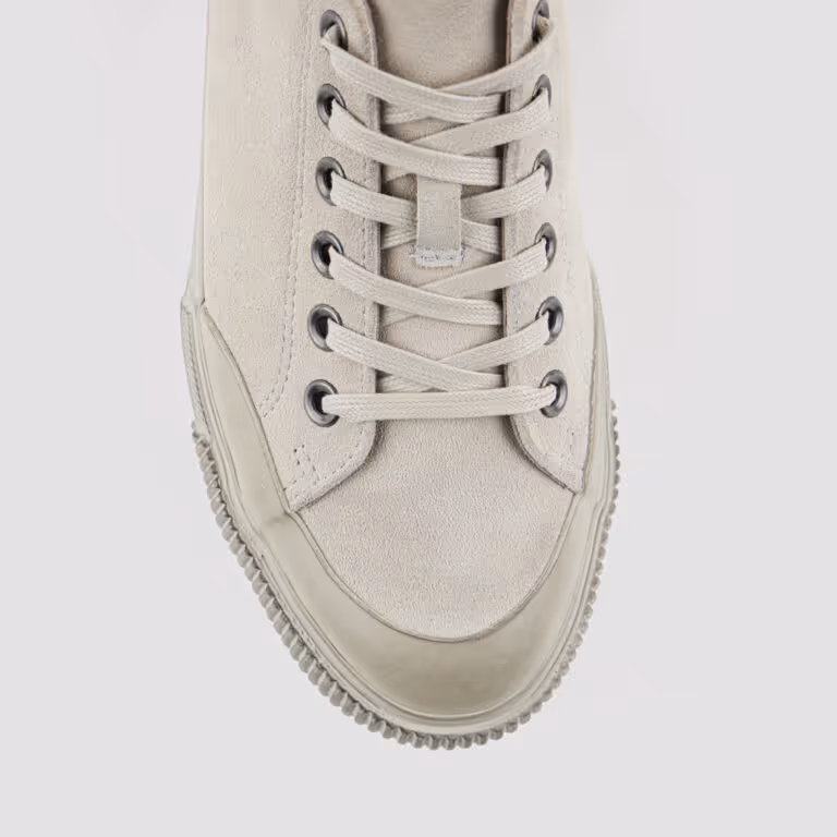 Top view of a light beige suede sneaker with matching laces and metal eyelets.