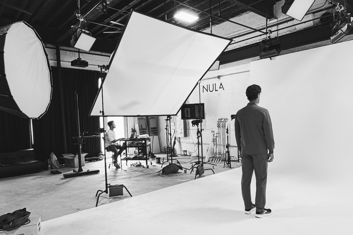 A studio shoot from the reverse angle with overhead scrim and lighting