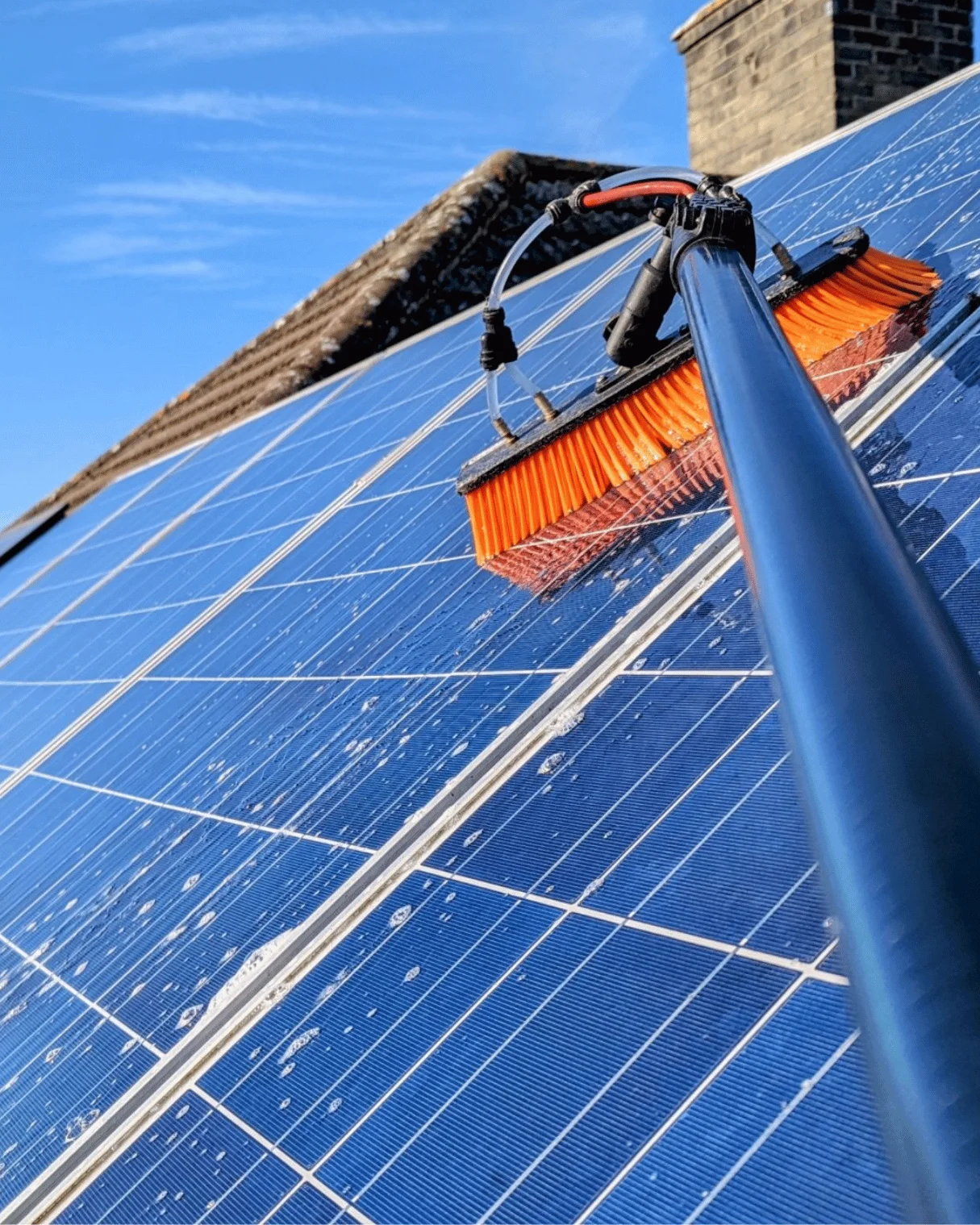 Dazzler team member cleaning solar hot water panels