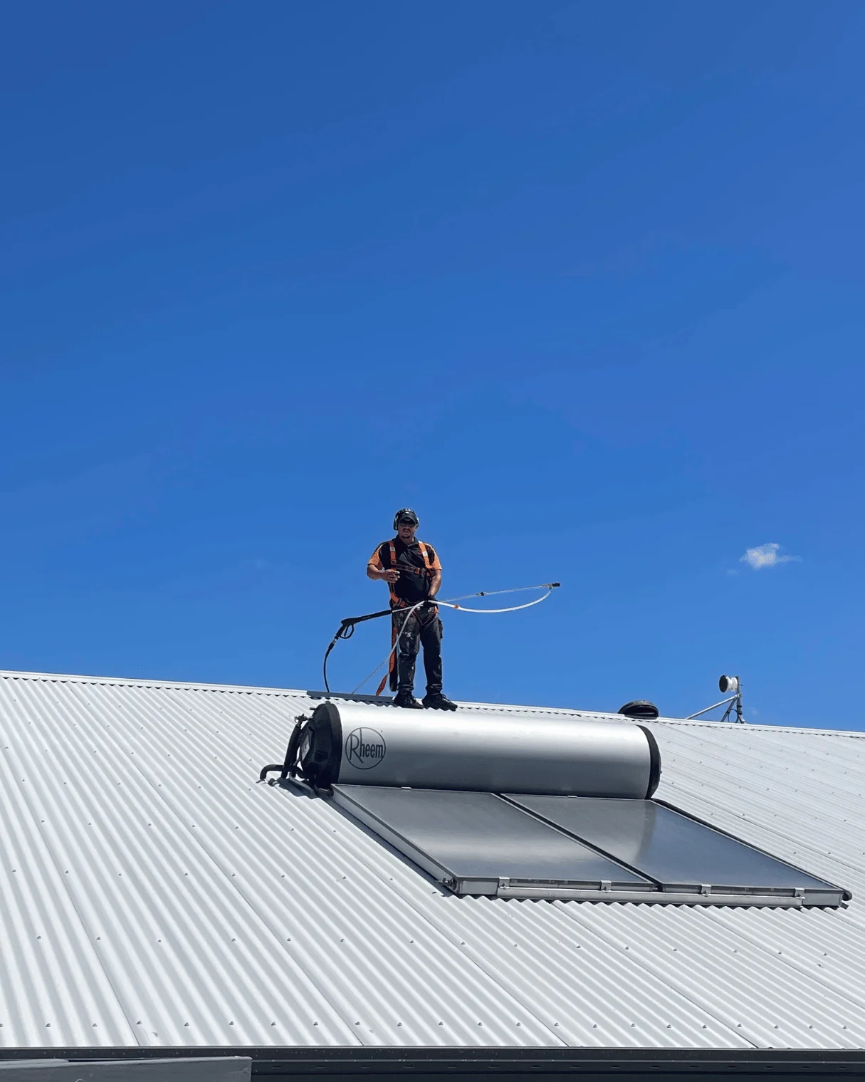 Dazzler team member cleaning solar hot water panels
