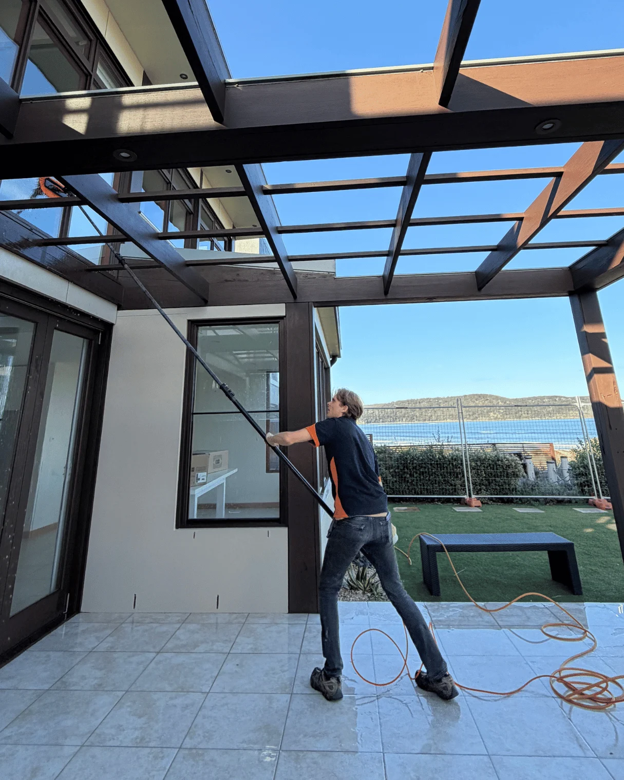 Dazzler team member cleaning windows with a water-fed pole