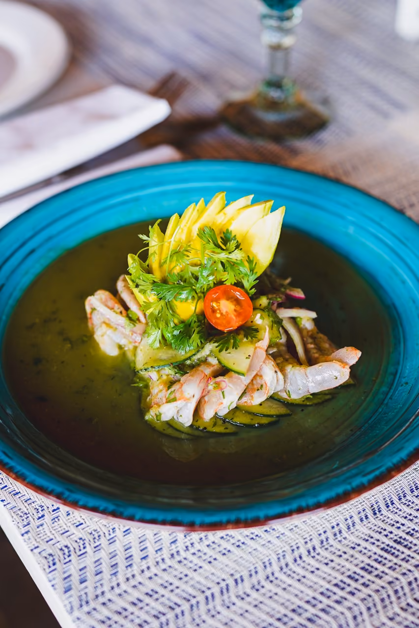 Stone crab enchiladas in poblano sauce on a turquoise plate at El Dorado