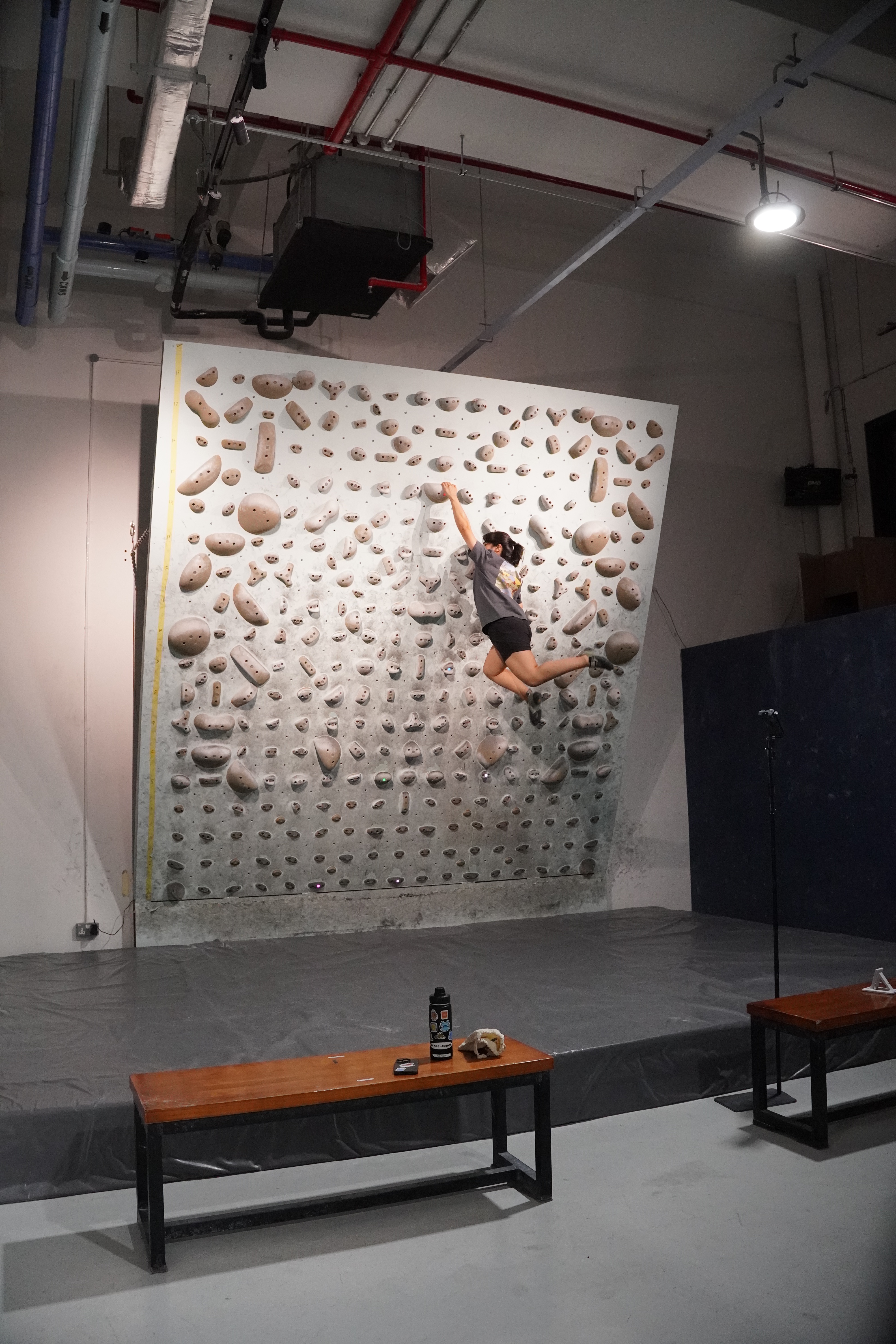 Coach spotting a beginner climber during a guided intro class