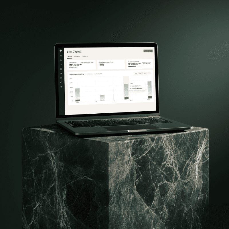 A laptop sitting on a marbled green block open to the Flex Capital dashboard through Flex. 