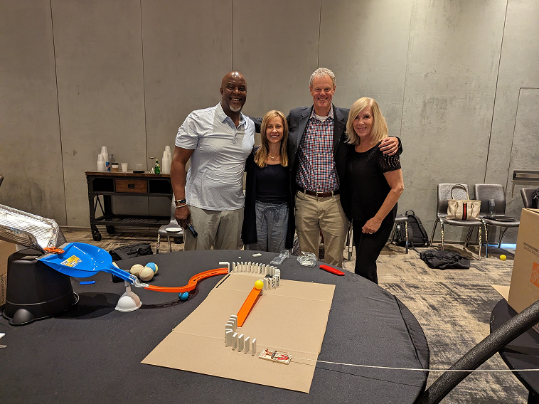 Team beside their chain-reaction build at a FullTilt Domino Effect event