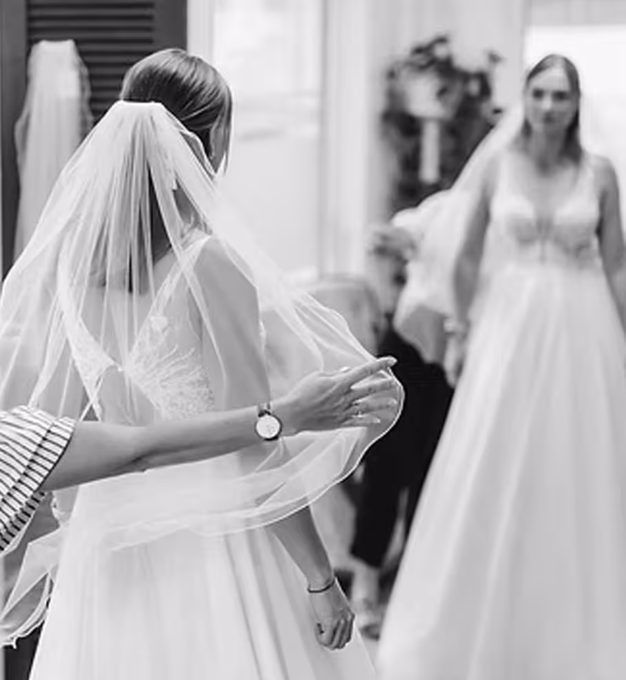 Frau in iner Änderungsschneiderei beim Anpassen des Hochzeitskleides