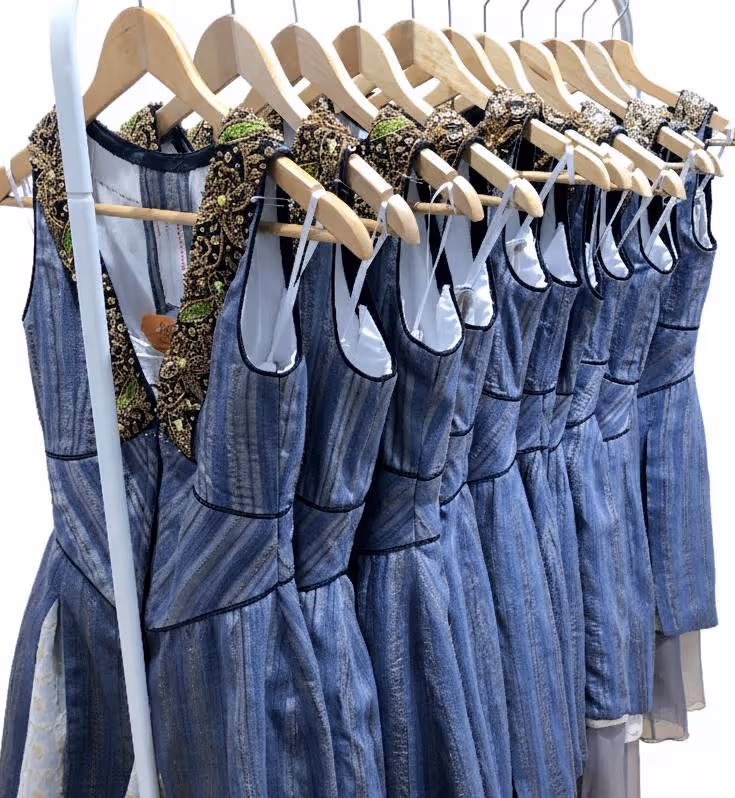 Theaterbühne mit mehrerern Schauspielern die alle aufwändige historische Kostüme tragen.