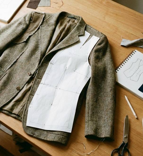 Schneiderpuppe mit Maßband und Stoff bedeckt als Sinnbild für die Anfertigung von Maßkleidung