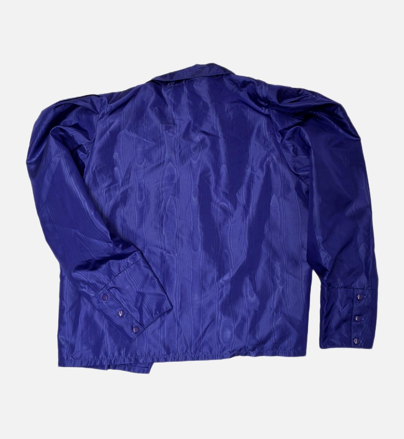 iese elegante Jacke aus dem Hause Etienne Aigner ist ein zeitloses Beispiel für europäische Luxuskonfektion. Gefertigt aus einer erstklassigen, wärmenden Schurwoll-Mischung, besticht das Stück durch seine klare, leicht strukturierte Oberfläche und eine haptische Tiefe, die typisch für das Traditionslabel ist. Das edle Schwarz wird durch die charakteristische Schnittführung und das hochwertige Innenfutter ergänzt, welches für maximalen Tragekomfort und eine perfekte Silhouette sorgt. Eine dezente Innentasche sowie die meisterhaft verarbeiteten Details unterstreichen den funktionalen Luxus dieses Vintage-Originals. Diese Jacke ist mehr als ein Kleidungsstück – sie ist ein Statement für bleibende Werte und eine Ästhetik, die weit über saisonale Trends hinausreicht.