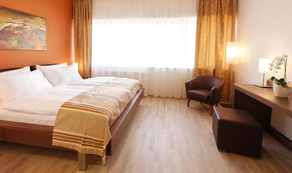 Stilvolles Doppelzimmer im Lava Inn Feldbach, Steiermark. Helle, moderne Einrichtung mit gemütlichem Bett, Schreibtisch & kostenlosem WLAN. Perfekt für Geschäftsreisende & Urlauber.