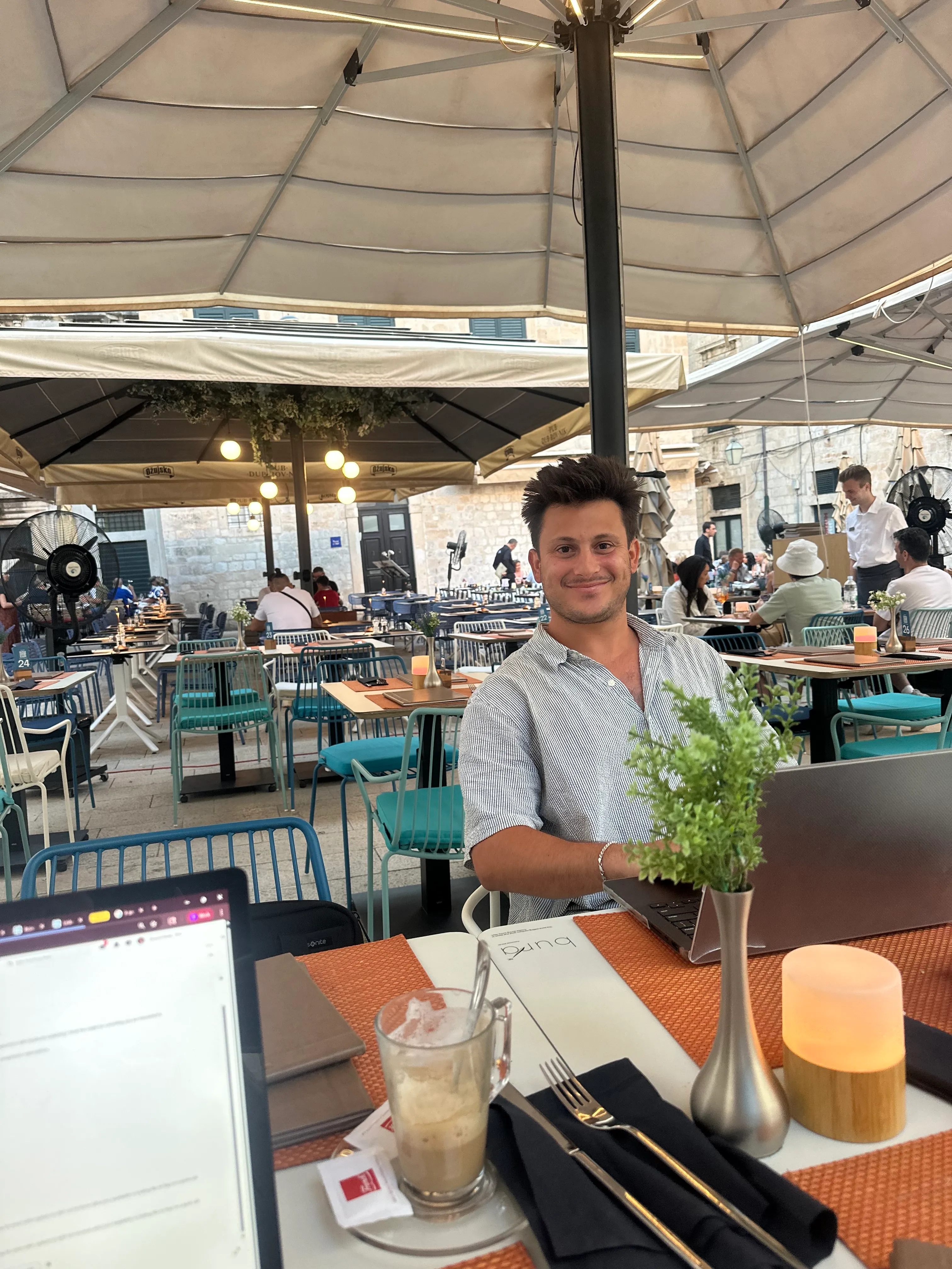 Man smiling and working on a laptop at