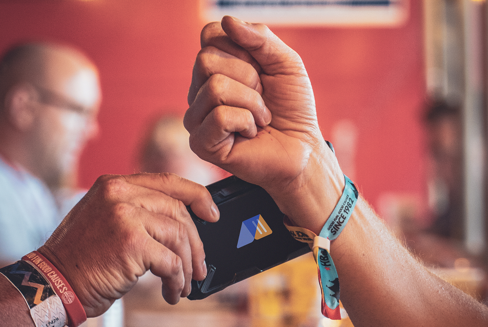 an RFID wristband gets scanned at an event for easy transactions