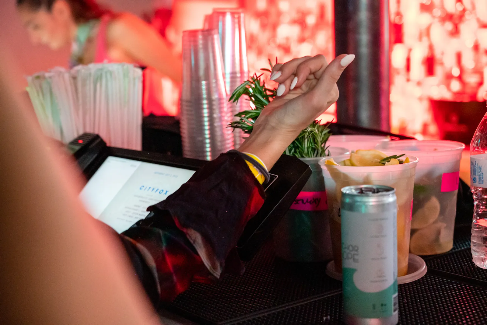 a woman's wrist scanning an RFID wristband to purchase beverages