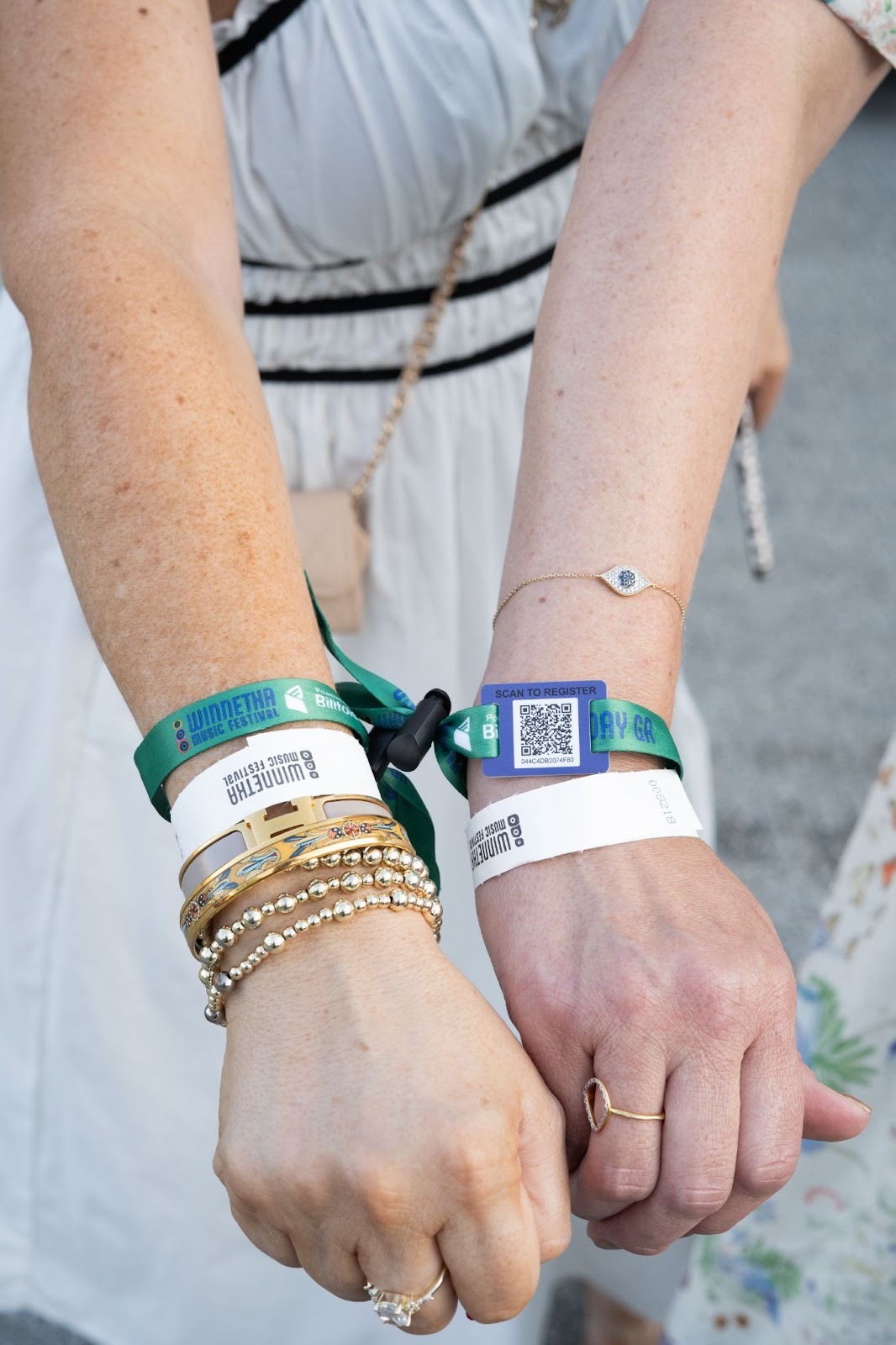 Festival attendees wearing multiple RFID payment wristbands for cashless transactions at music events
