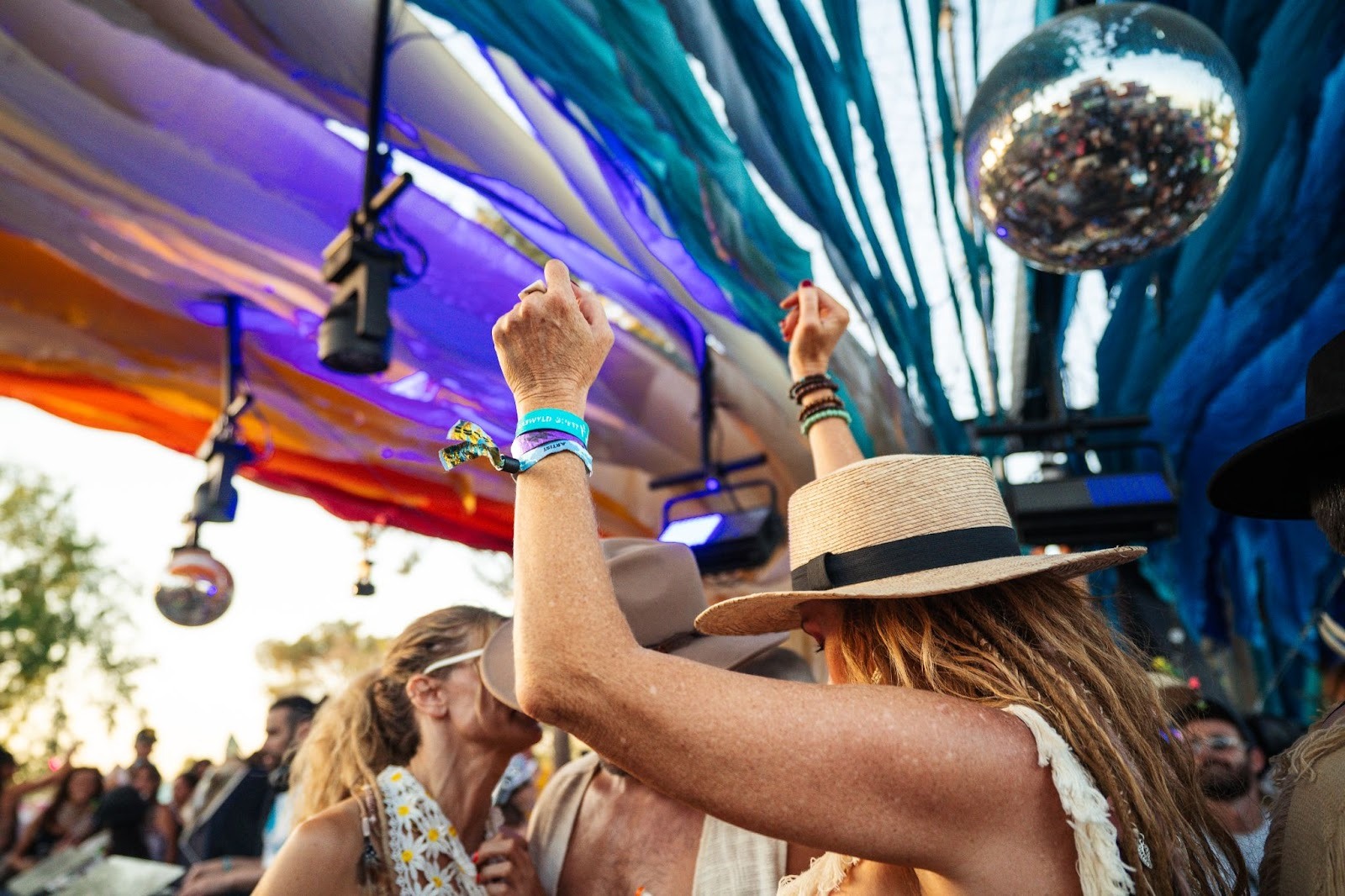 Festivalgoers dancing with hands raised wearing RFID event wristbands at a live event