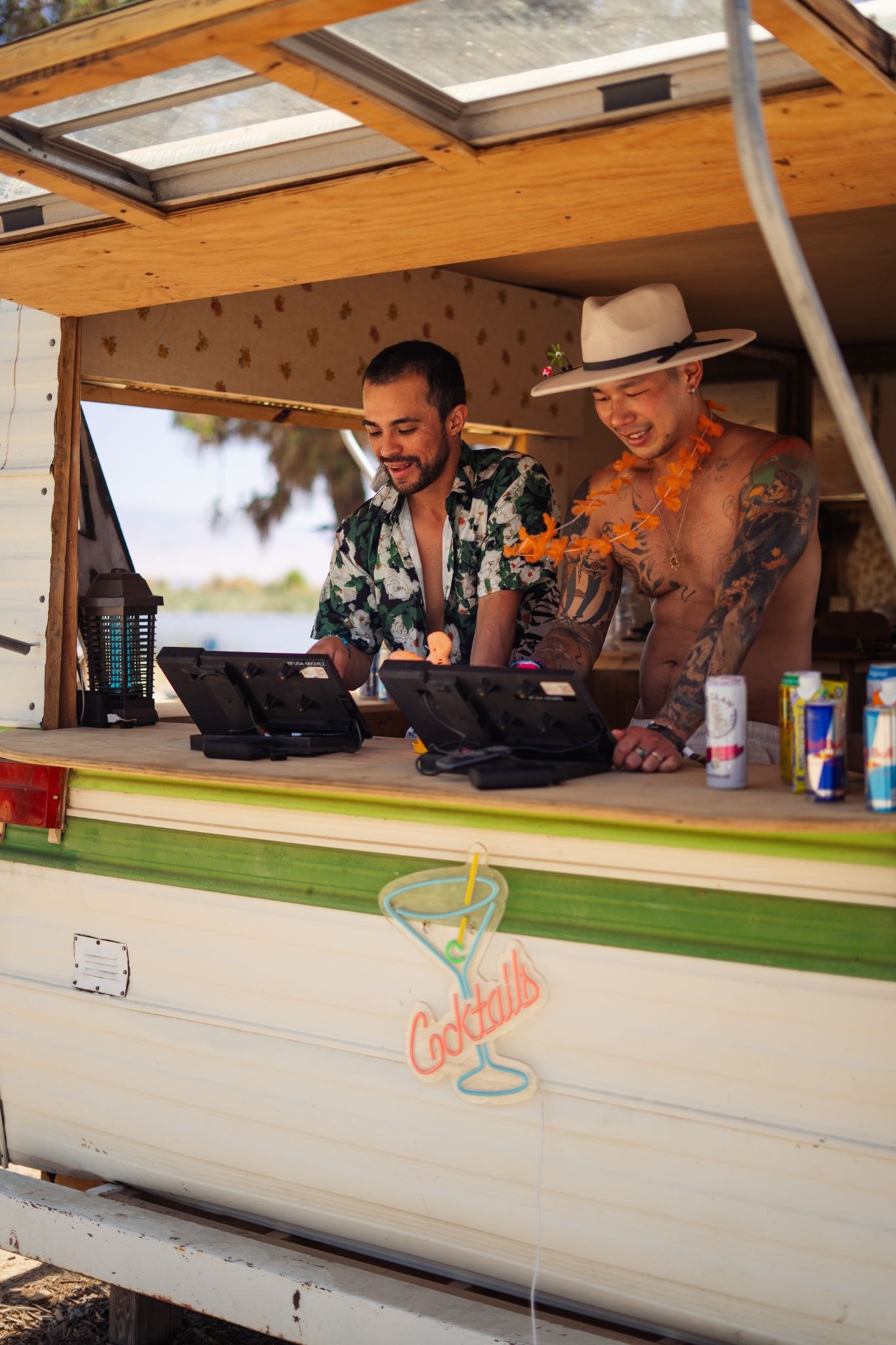 Festival vendors operating a contactless POS tablet at an outdoor cocktail bar setup