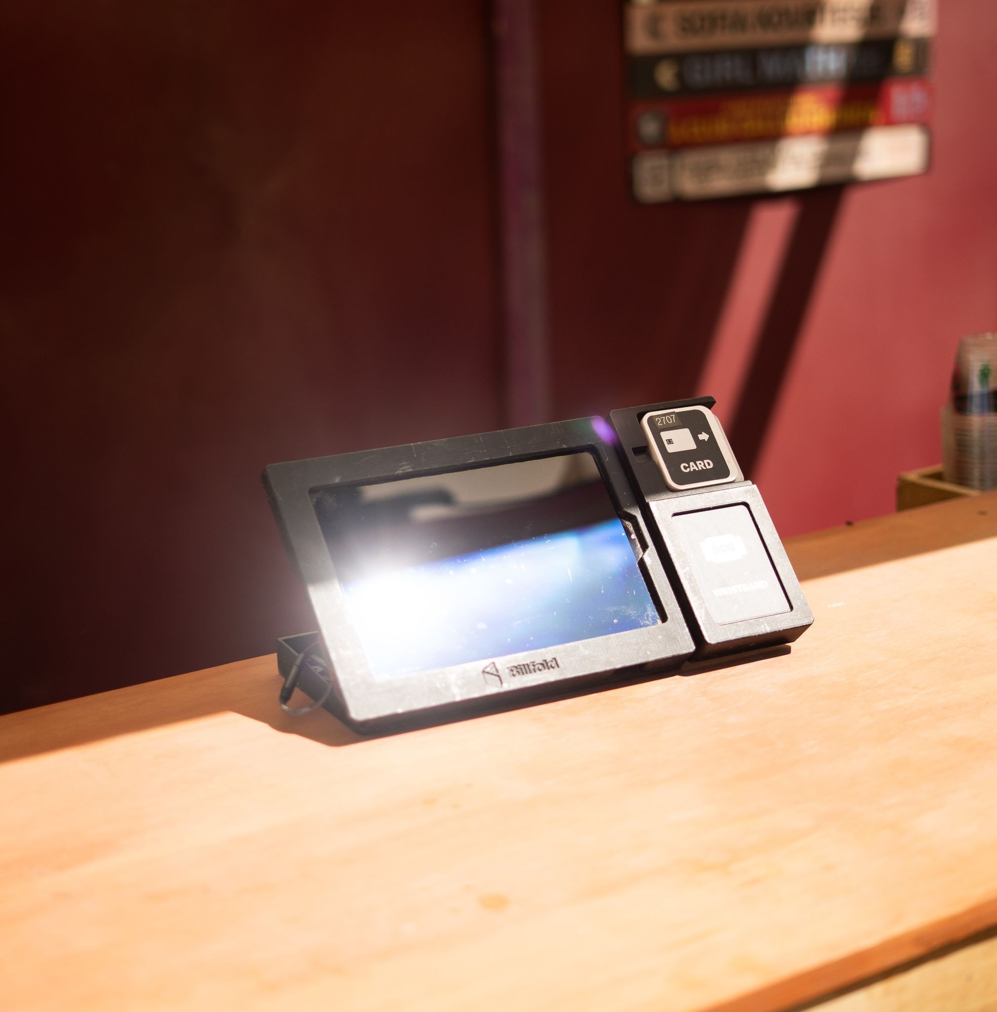 Contactless POS terminal tablet on a counter at a music event beverage booth