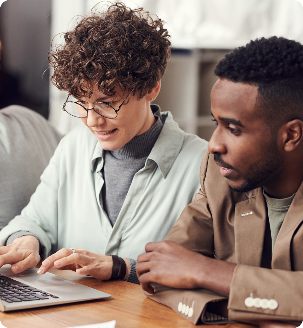 Two coworkers looking at laptop