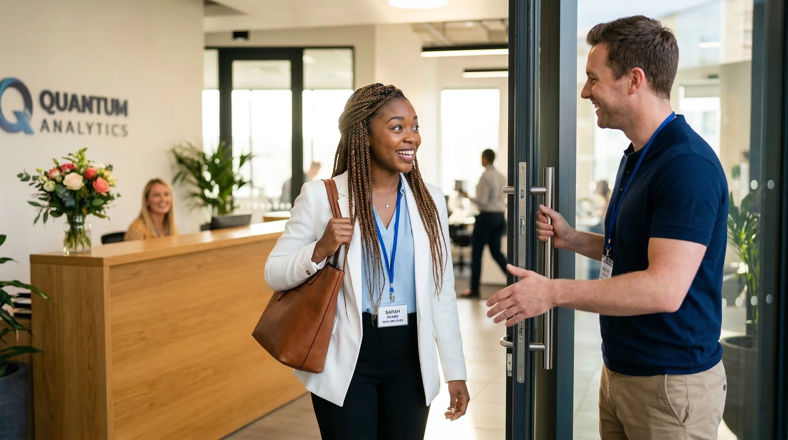 Nouvelle collaboratrice accueillie par un collegue a l'entree d'un bureau moderne le premier jour