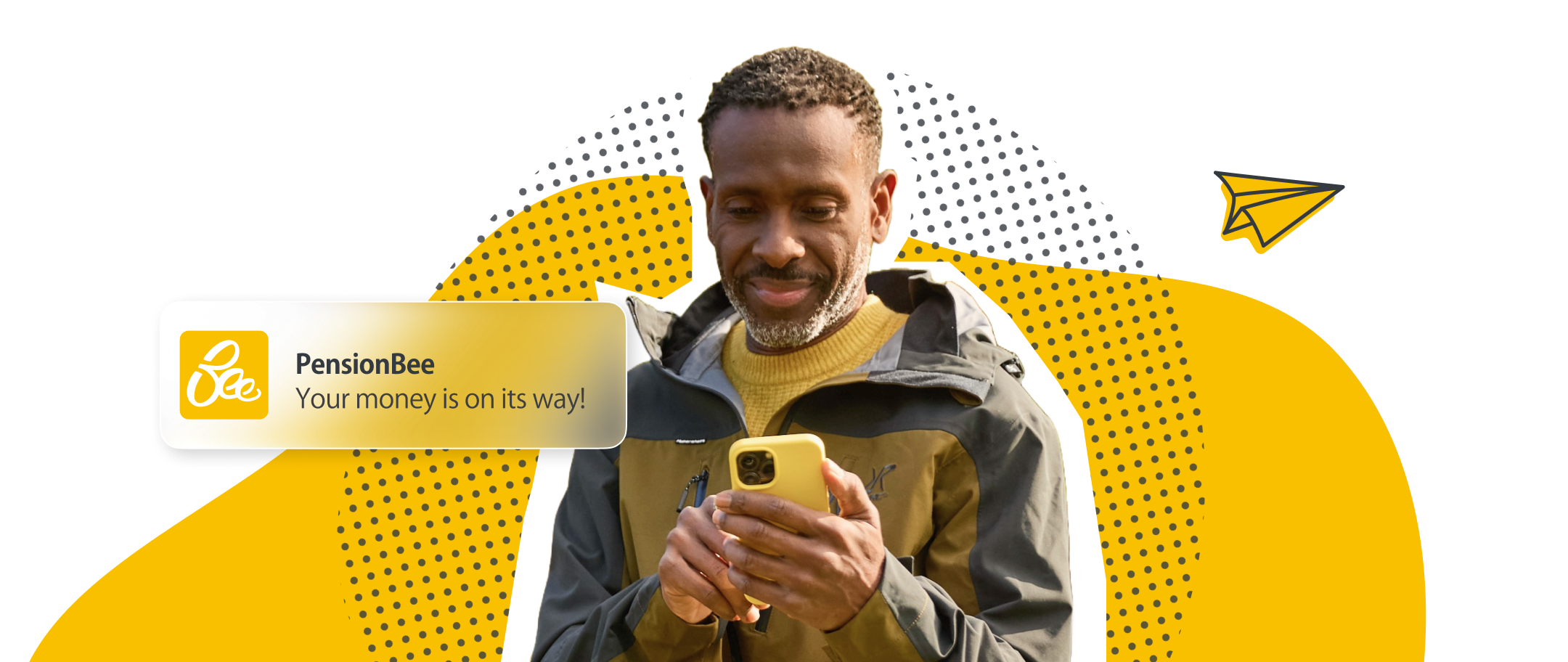 Man in outdoor jacket looking at a yellow smartphone with PensionBee notification saying 'Your money is on its way!'