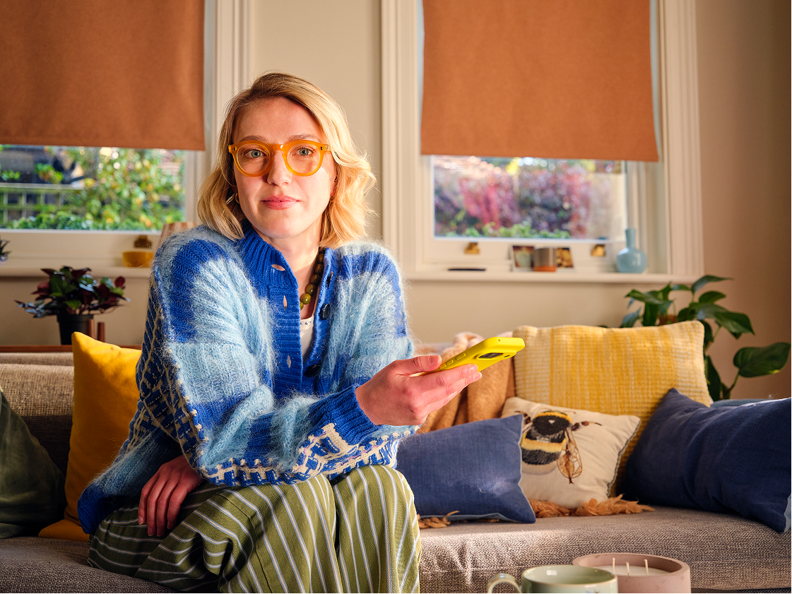 Woman smiling at her phone at home