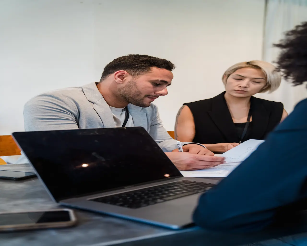 Trois recruteurs discutent autour d'une table