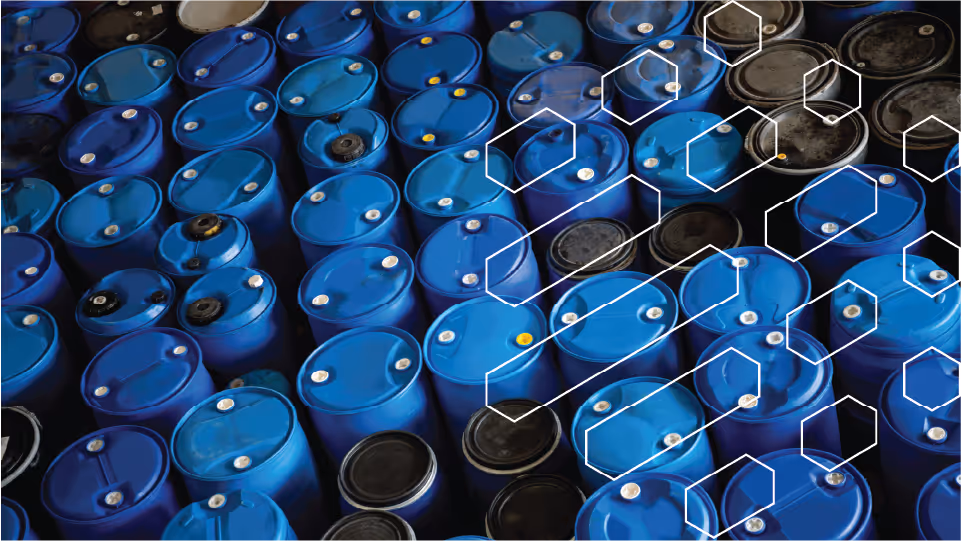 Rows of blue and black industrial barrels stacked closely together with overlay of white hexagonal patterns.