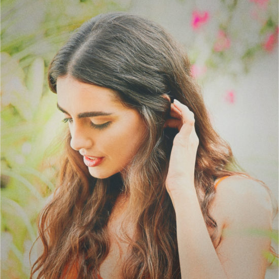 A girl arranges her hair with a filter