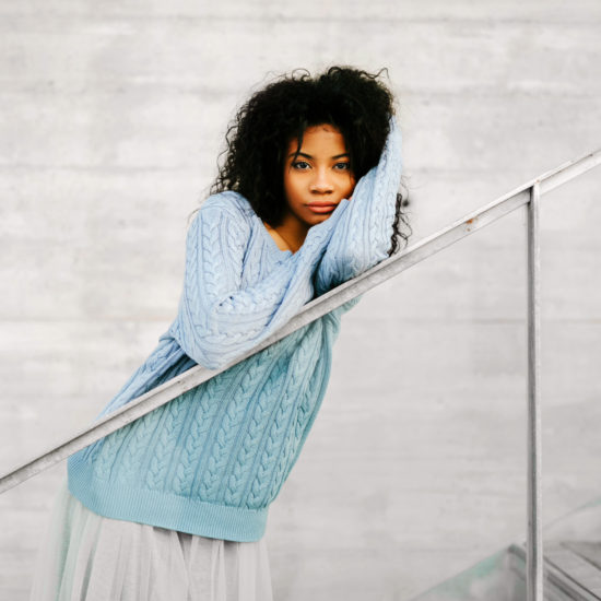 A woman with  curly hair on a straight railing