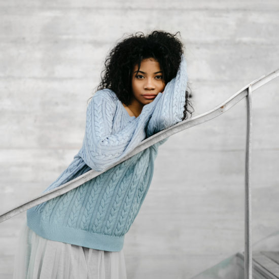 A woman with curly hair on a crooked railing