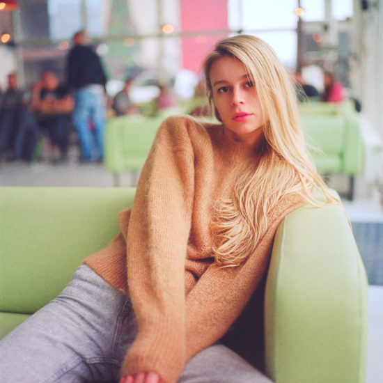 Blonde girl with sitting on a couch