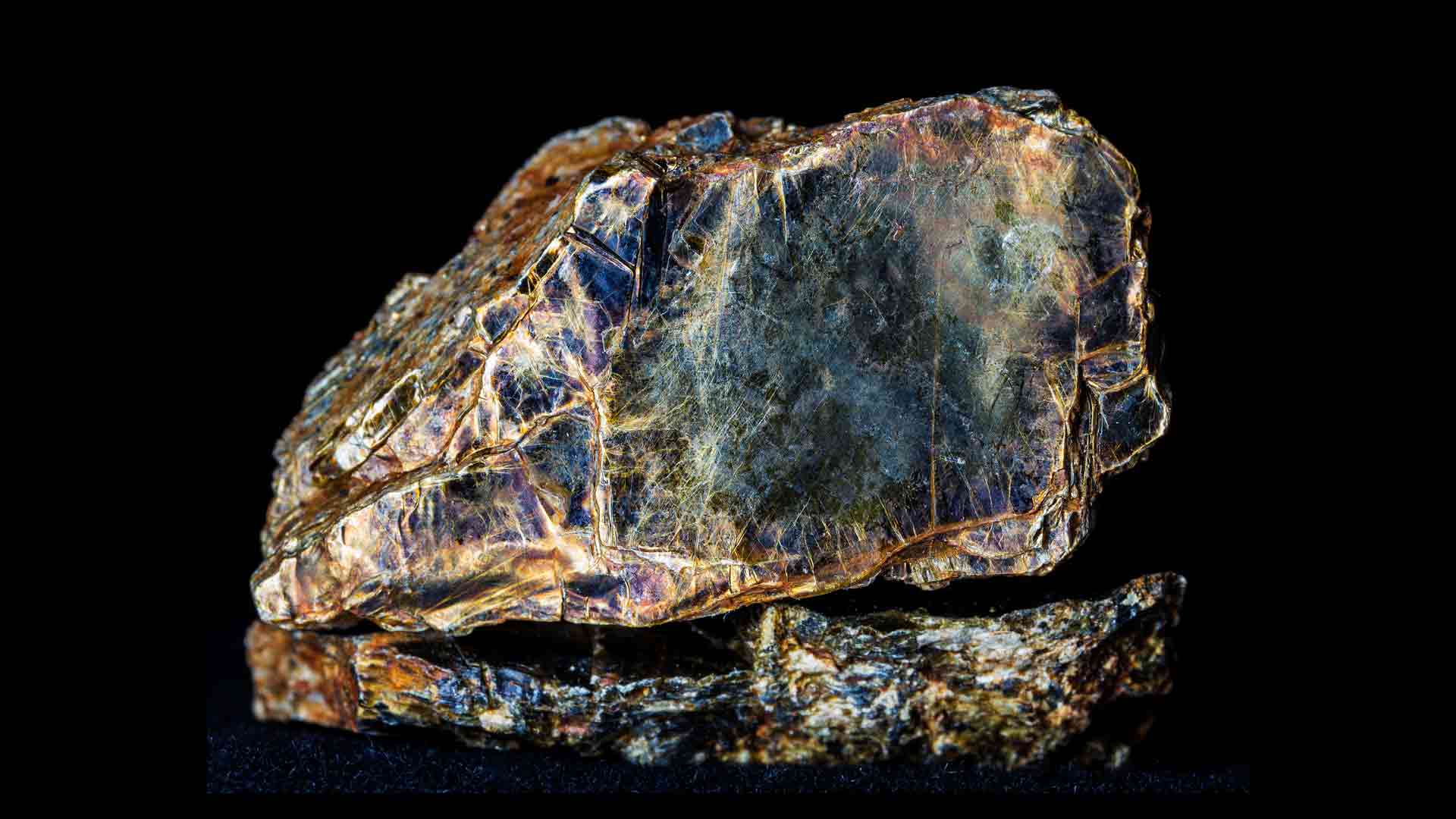 Biotite (black mica) mineral on black background.