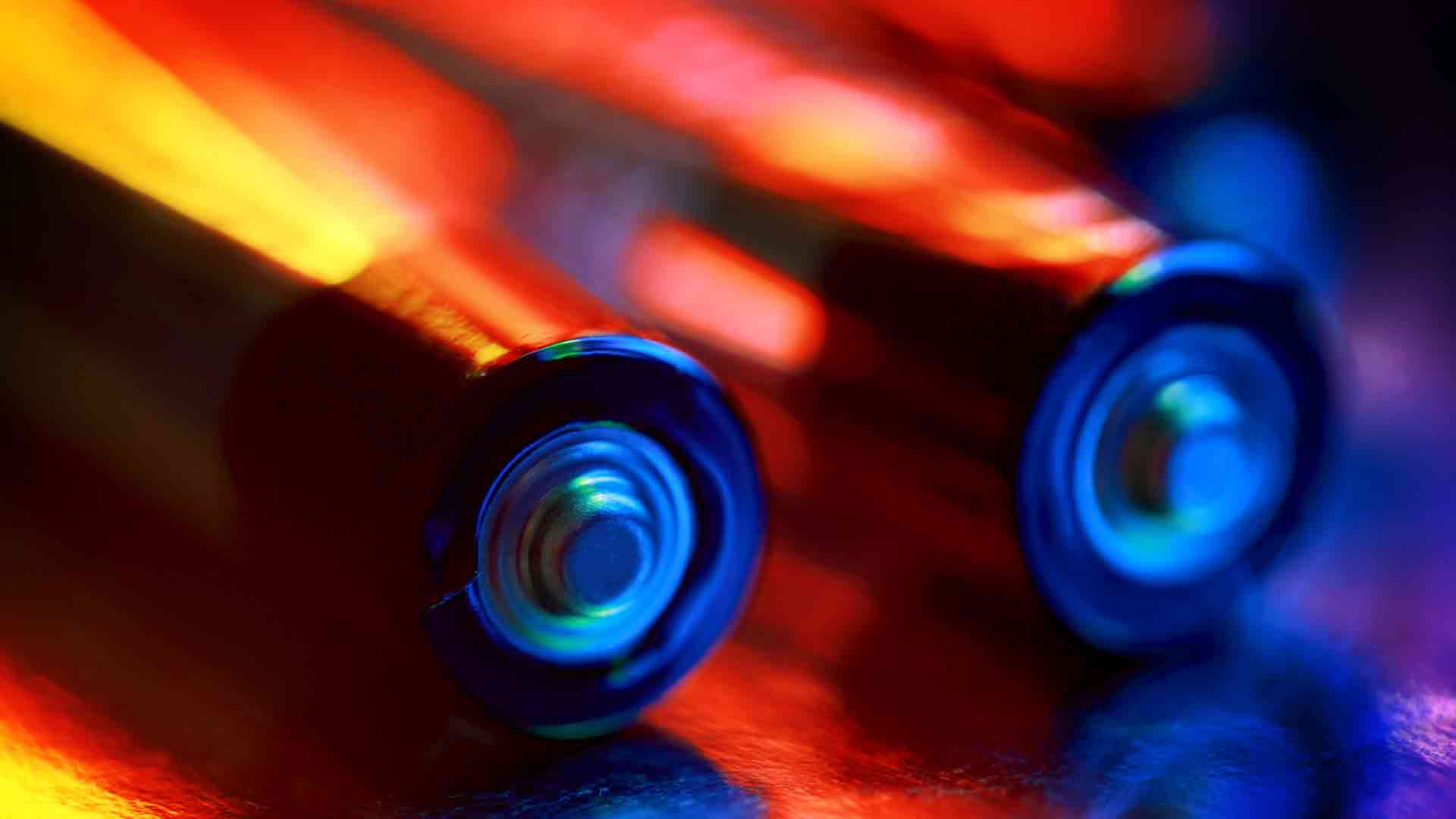 Image of AA batteries on an abstract, colorful background.