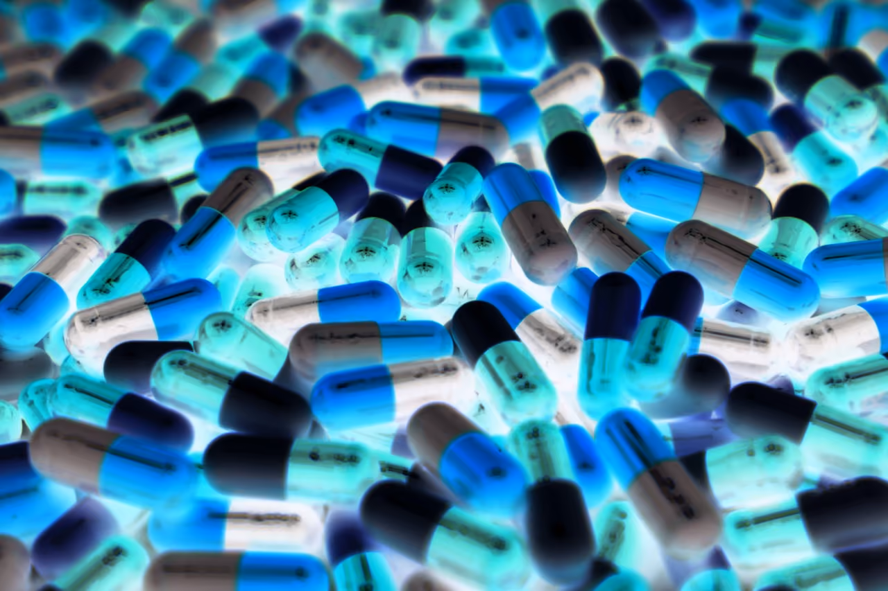 Close-up of many capsules glowing blue and white scattered densely.